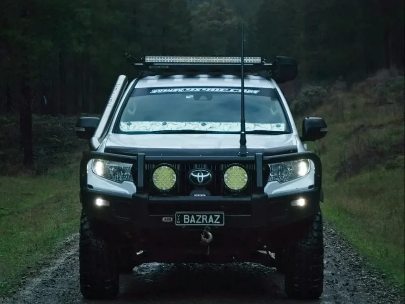 4x4 on a dirt road with a forest behind it.